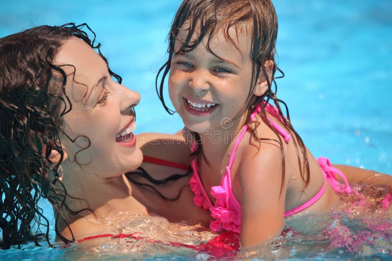 Smiling woman and little girl bathes in pool royalty free stock image Smiling woman and little girl bathes in pool royalty free stock image