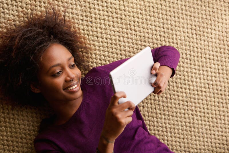 Smiling woman lying down with digital tablet