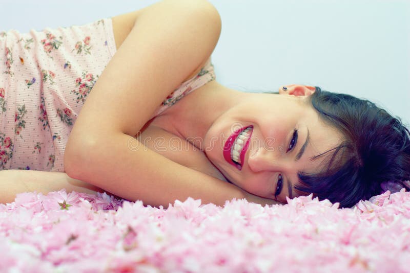 Smiling woman lying in flower petals