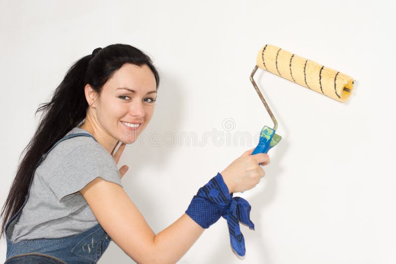 Smiling woman painting her house