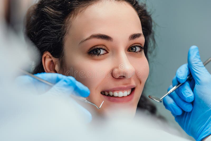 Smiling woman sitting in dentist chair ready for a dental check-up. Close up view royalty free stock photos
