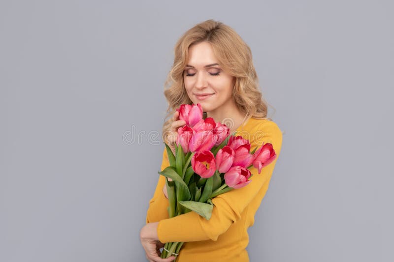 smiling woman smell tulips. lady hold flowers for spring holiday. girl with bouquet royalty free stock images