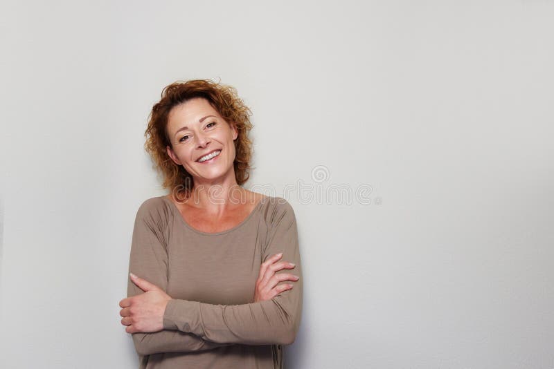 Smiling woman standing with arms crossed stock image