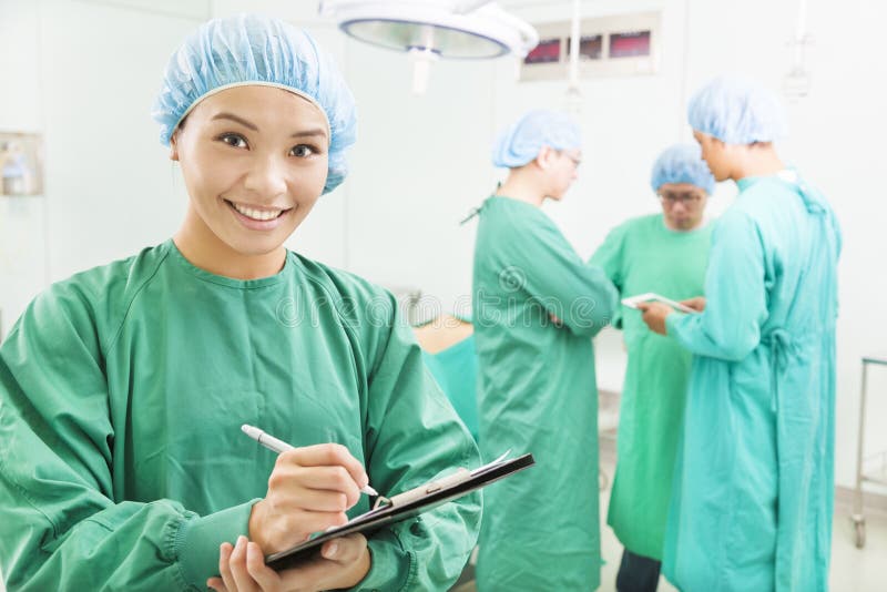 Smiling woman surgeons writing patient operating records