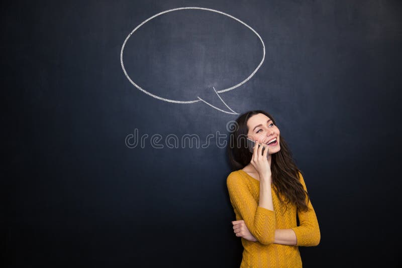 Smiling woman talking on mobile phone over chalkboard background stock photos