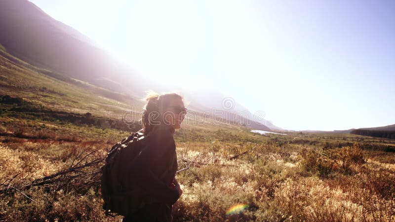 Smiling woman walking through grass field