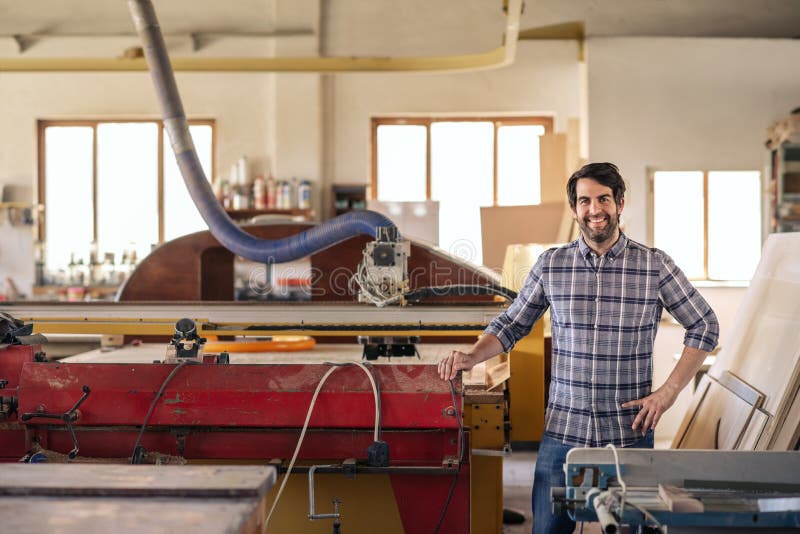 Smiling Woodworker Discussing Designs Over a Cellphone and Working