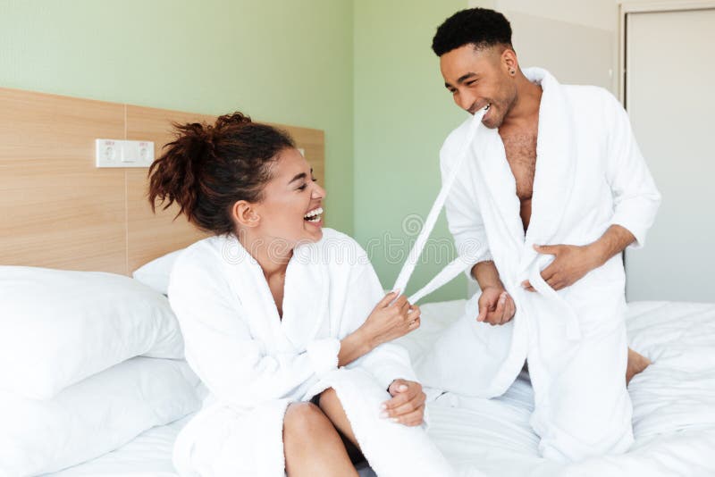 Smiling young african loving couple sitting on bed stock photography Smiling young african loving couple sitting on bed stock photography