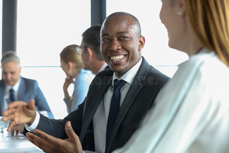 Smiling young businessman discussing with female colleague in board room stock photos Smiling young businessman discussing with female colleague in board room stock photos