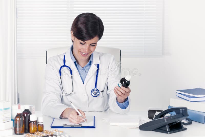 Smiling young doctor writing out a prescription