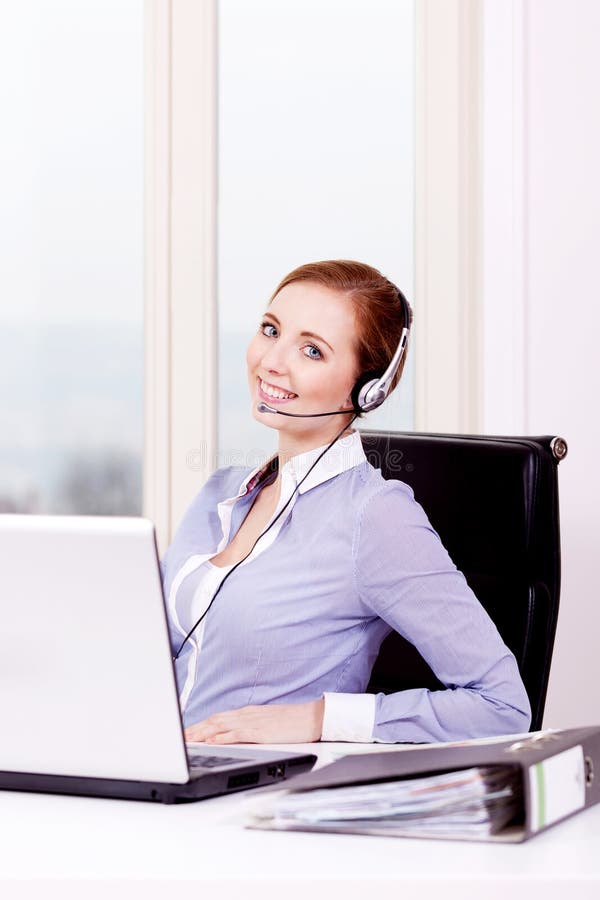 Smiling young female callcenter agent with headset stock images