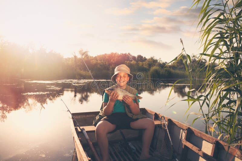 Smiling young fisher boy showing his first fish catch stock images Smiling young fisher boy showing his first fish catch stock images