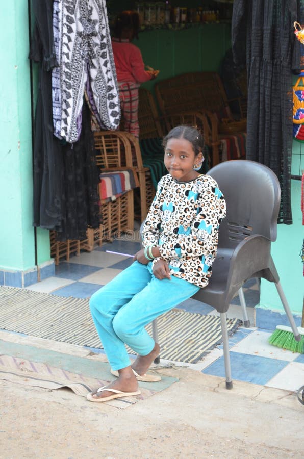 Smiling Young Girl Seated Outside Store in Egypt royalty free stock images Smiling Young Girl Seated Outside Store in Egypt royalty free stock images