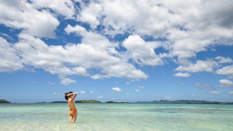 Young Girl Stands In Shallow Water Looking At Horizon Stock Image