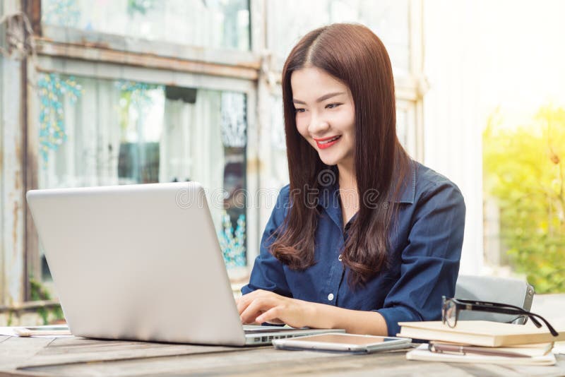 Smiling young happy asian woman using technology on her laptop c royalty free stock photos Smiling young happy asian woman using technology on her laptop c royalty free stock photos