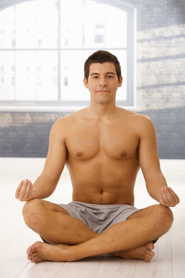 Smiling young man meditating royalty free stock photography
