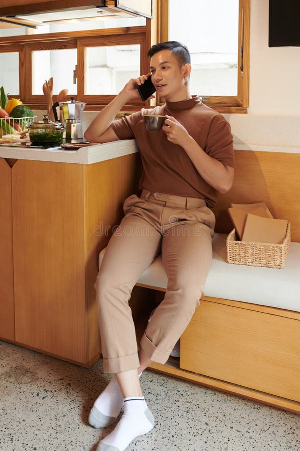 https://thumbs.dreamstime.com/b/smiling-young-man-sitting-kitchen-counter-drinking-tea-talking-phone-friend-man-drinking-tea-calling-250325754.jpg