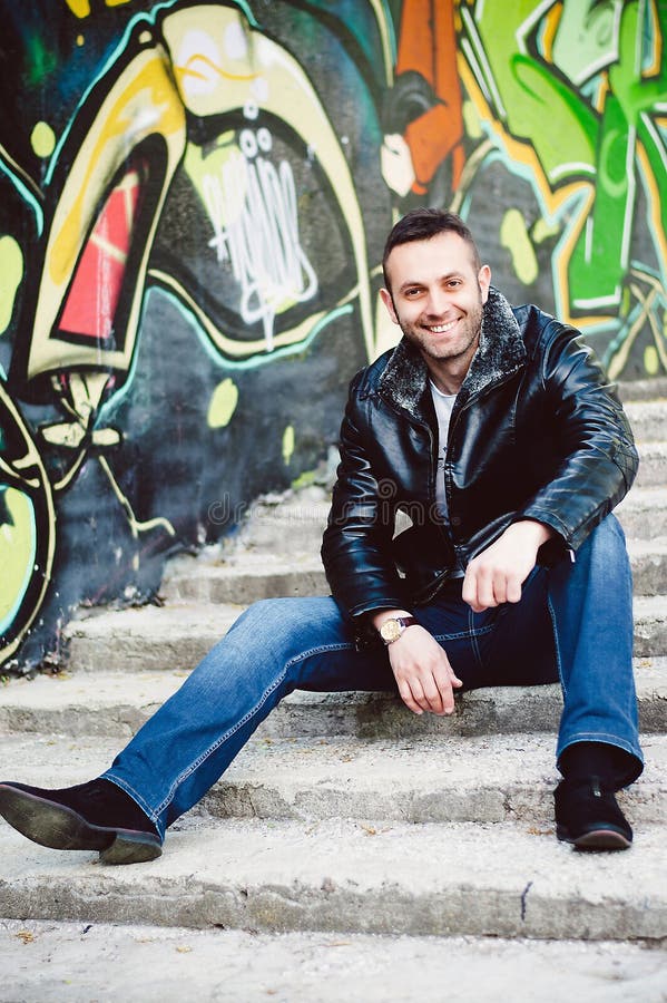 Smiling young man sitting on the stairs