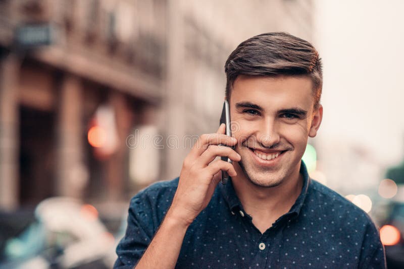 Smiling Young Man Talking on His Cellphone in the City Stock Im image photo