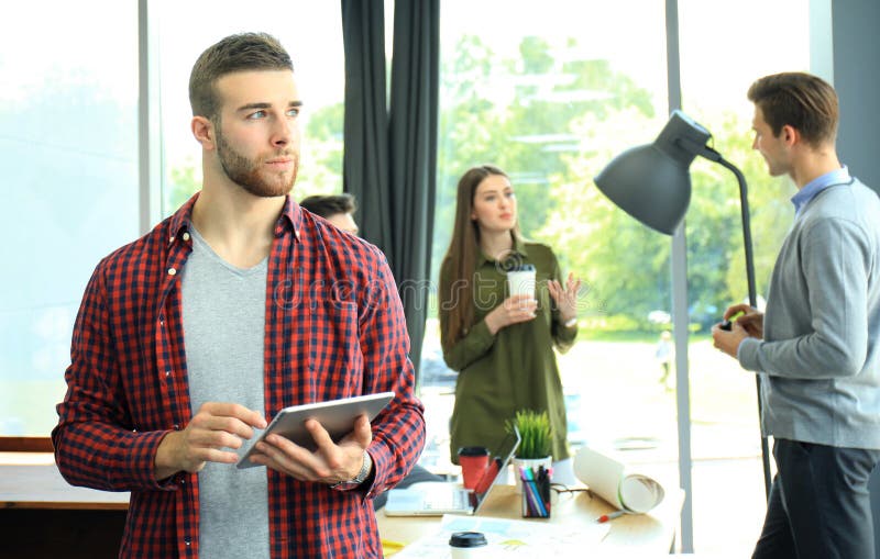 Smiling young man using digital tablet in the office. stock photos Smiling young man using digital tablet in the office. stock photos
