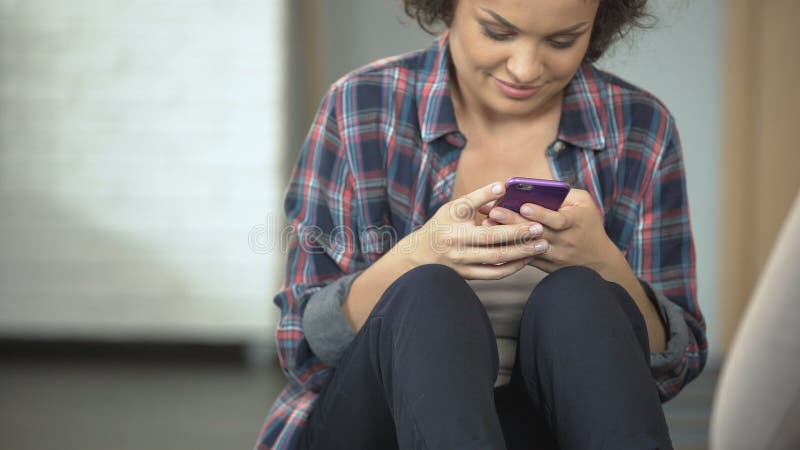 Smiling young woman chats with friends on phone, social media applications