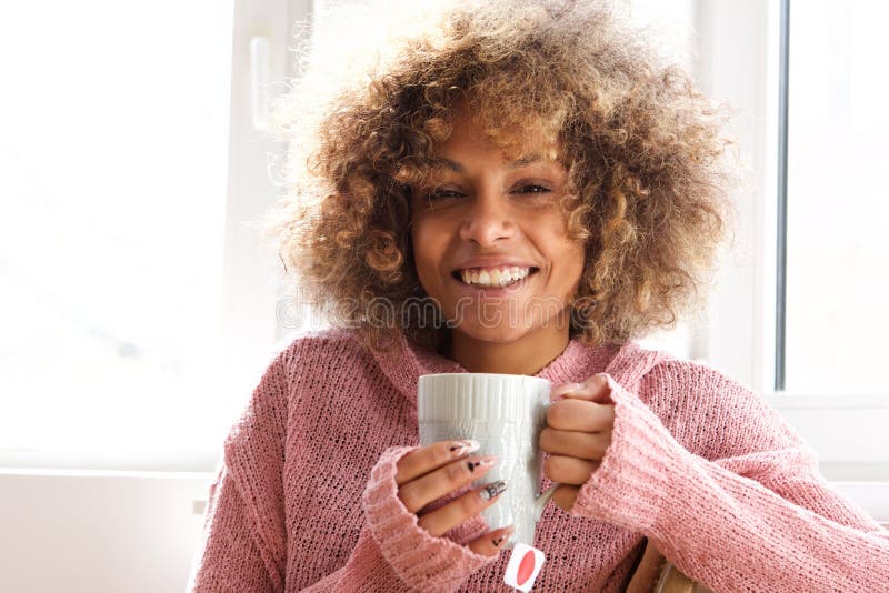 Smiling young woman with cup of tea