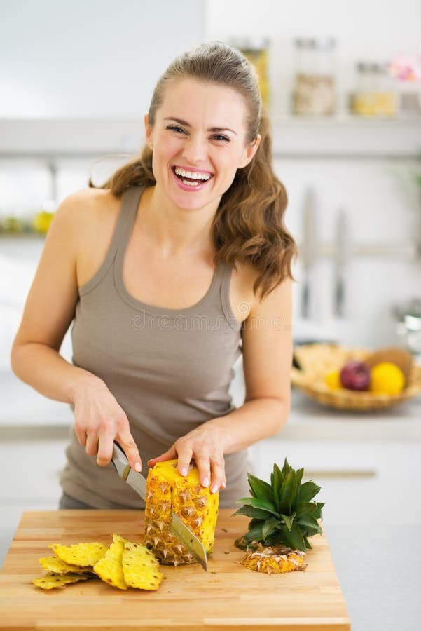 Smiling young woman cutting pineapple. high-resolution photo. Cut smiling stock images, royalty-free photos and pictures