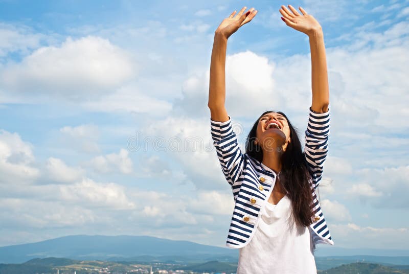 Smiling young woman lifted hands to sky stock photo Smiling young woman lifted hands to sky stock photo