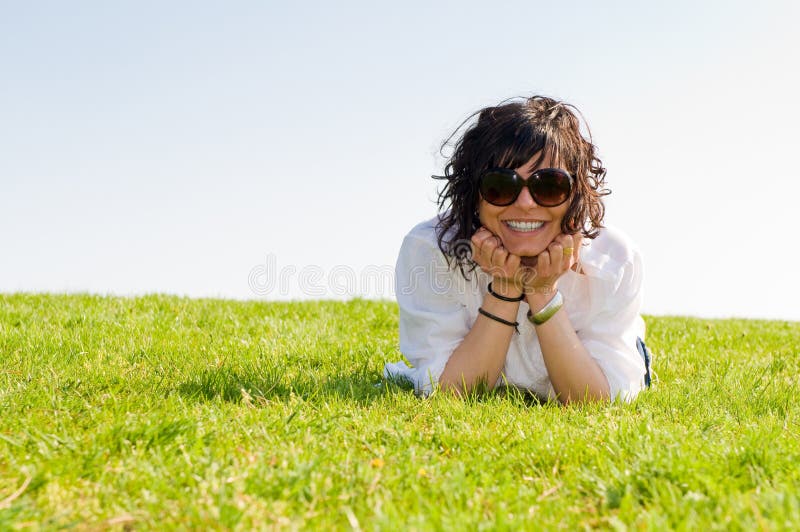 Smiling young woman lying on the grass