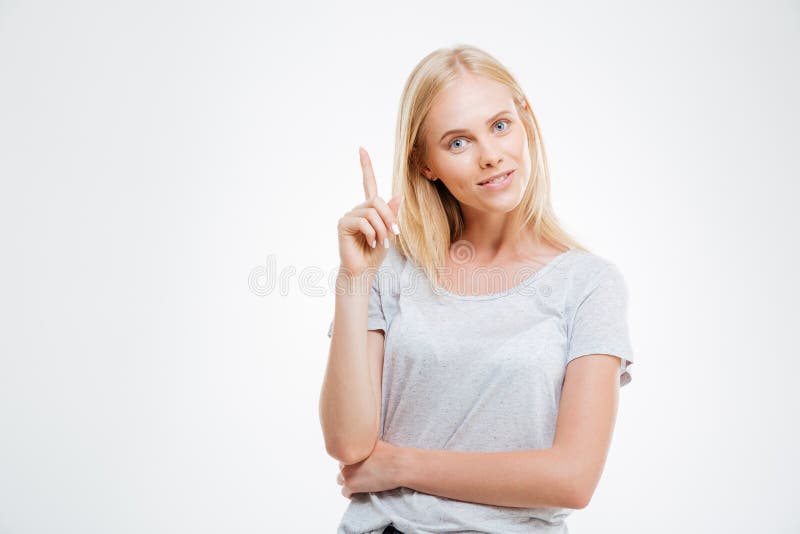 Smiling young woman pointing finger up