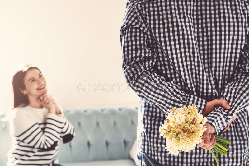 Smiling young woman receiving white daffodil as love gift from her boyfriend stock photography Smiling young woman receiving white daffodil as love gift from her boyfriend stock photography