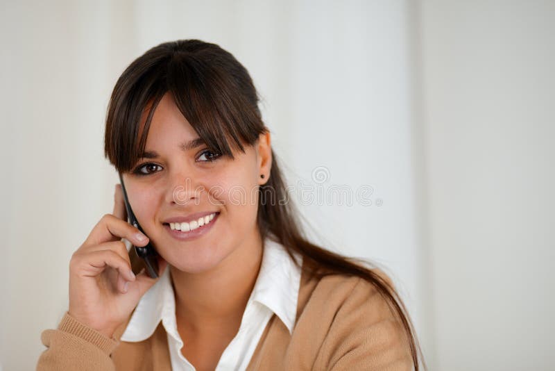 Smiling young woman speaking on cellphone