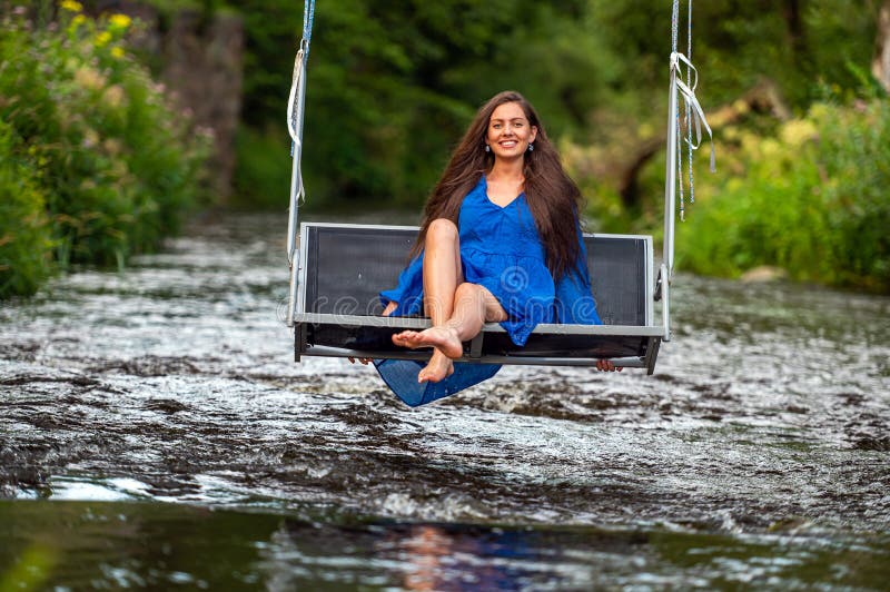 A Joyful Young Woman Swings on a Rope Swing Across a Fast-flowing River  Stock Image - Image of forest, rest: 260856783