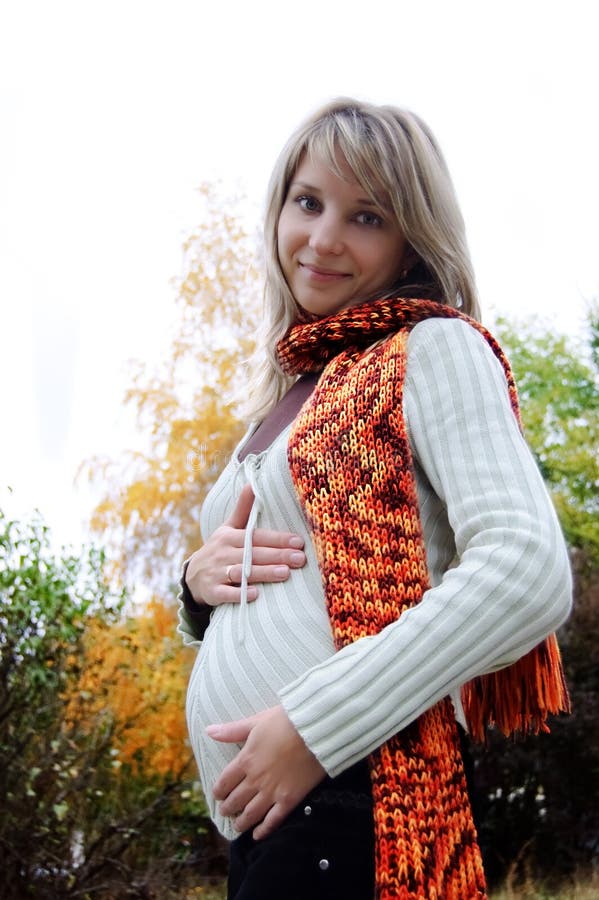 Smilng pregnant woman in autumn