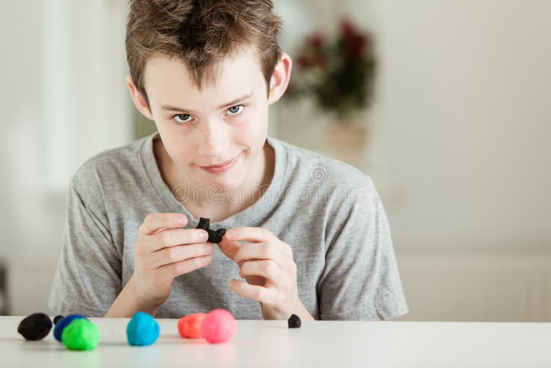 Smirkingskind het spelen met stukken van klei royalty-vrije stock afbeelding Smirkingskind het spelen met stukken van klei royalty-vrije stock afbeelding