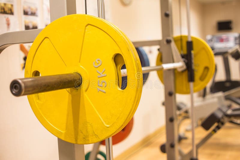 Smith machine barbell in fitness room for weight training and muscle building