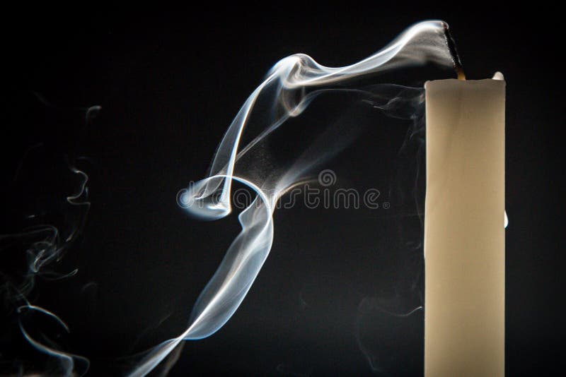 Smoke and extinct candle on a black background