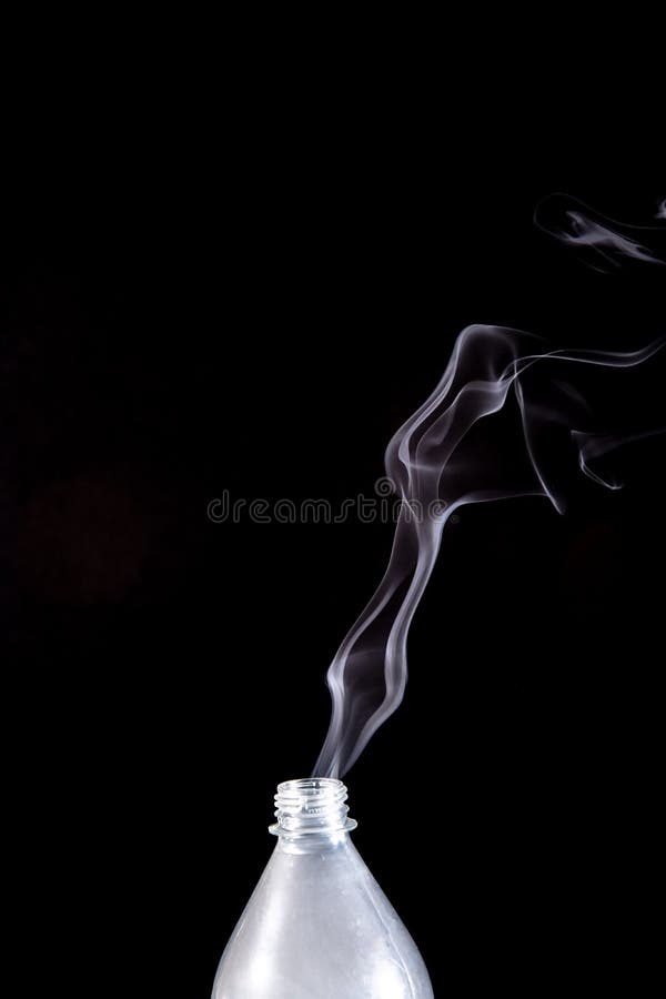 Smoke Coming Out of a Plastic Bottle Against a Black Background Stock