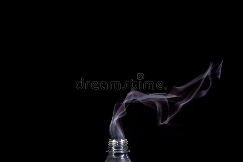 Smoke Coming Out of a Plastic Bottle Against a Black Background Stock
