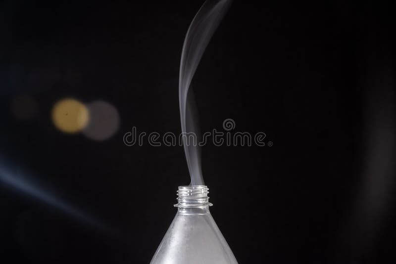Smoke Coming Out of a Plastic Bottle Against a Black Background with