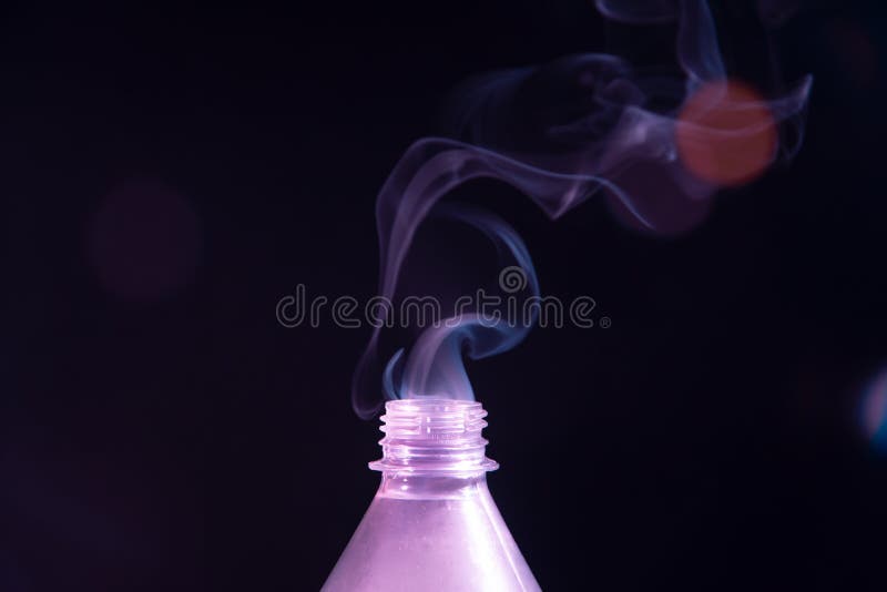 Smoke Coming Out of a Plastic Bottle Against a Black Background with