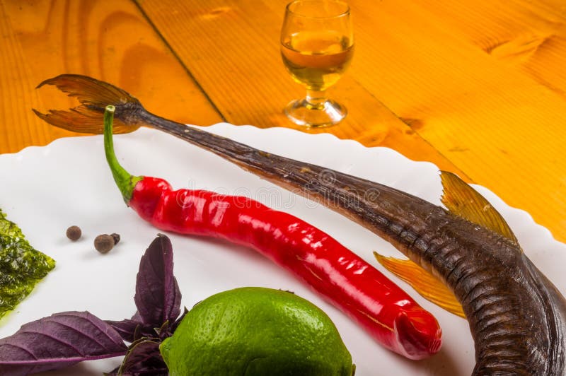 smoked garfish with lime, Basil, green onions, chili, nori chips, spices, olive oil in a white ceramic dish, on a wooden table royalty free stock image smoked garfish with lime, Basil, green onions, chili, nori chips, spices, olive oil in a white ceramic dish, on a wooden table royalty free stock image