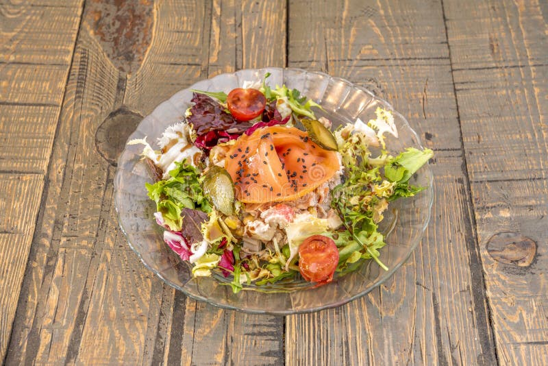 Smoked salmon salad with pickled gherkins, cherry tomatoes, iceberg lettuce, endive and arugula, sweet corn