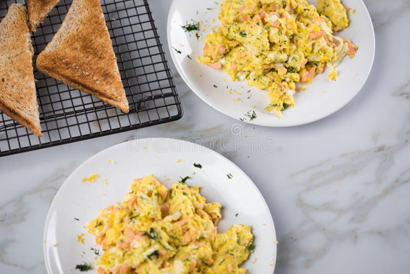 Smoked salmon with scrambled eggs, whole grain bread toast and dill on marble background royalty free stock image Smoked salmon with scrambled eggs, whole grain bread toast and dill on marble background royalty free stock image