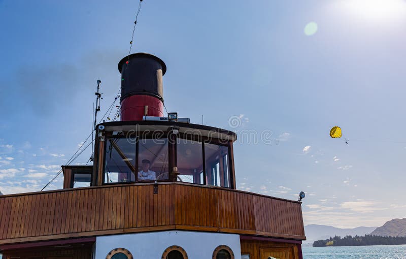 The smokestack or funnel of the TSS Earnslaw Steamship with a paraglider in the sky on lake Wakatipu Queensland New Zealand. royalty free stock photo The smokestack or funnel of the TSS Earnslaw Steamship with a paraglider in the sky on lake Wakatipu Queensland New Zealand. royalty free stock photo