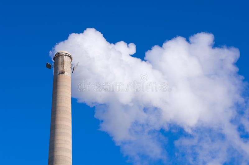 Smokestack-und Gas-Emissionen gegen blauen Himmel