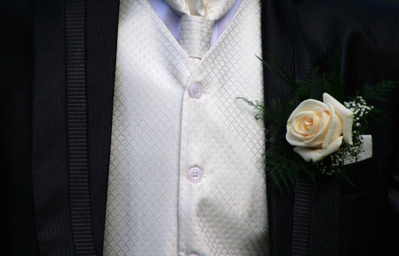 A groom in tuxedo with rose. A groom in tuxedo with rose.