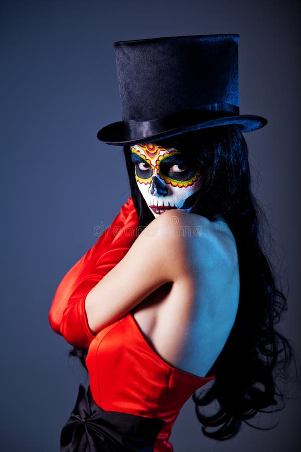 Sugar skull girl in tophat and red dress, studio shot. Sugar skull girl in tophat and red dress, studio shot