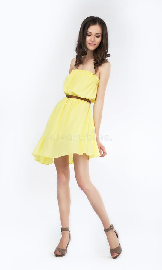 Trendy young woman in funky yellow dress smiling against white background. Trendy young woman in funky yellow dress smiling against white background