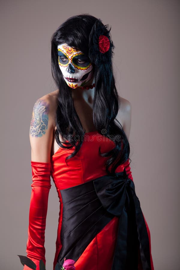 Sugar skull girl in red evening dress, studio shot. Sugar skull girl in red evening dress, studio shot